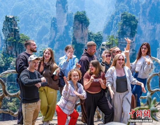 Foreign tourists pose for a group photo at the Zhangjiajie National Forest Park in Hunan Province.