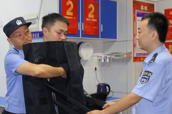 Police officers demonstrate the portable restraint blanket in Wuhan, Hubei Province. (Screenshot photo from CCTV News)