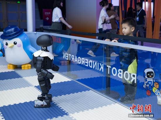 A robot attracts a child at the HICOOL 2026 Global Entrepreneur Summit in Beijing, Aug. 27, 2026. (Photo/China News Service)
