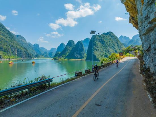 Cyclists race through Guangxi's karst landscape