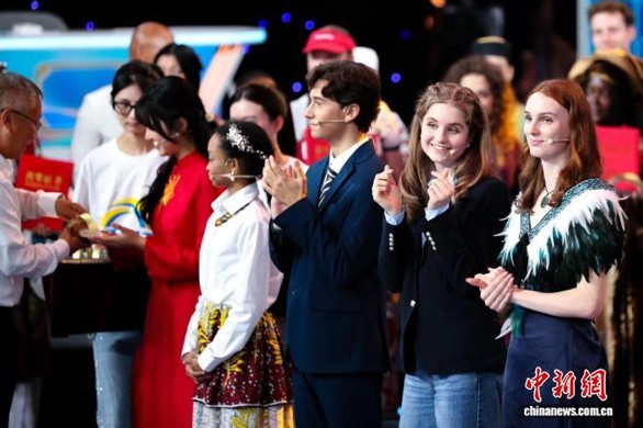 U.S. contestant Willa Brubaker (second right) makes a heart gesture at the award ceremony after winning the global title at the 19th Chinese Bridge—Chinese Proficiency Competition for Foreign Secondary School Students in Tianjin on Sept. 21, 2026. (Photo: China News Service/Tong Yu)