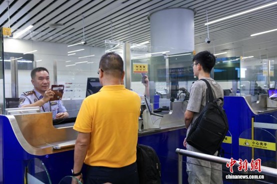 Immigration officers assist travelers with entry and exit formalities at Baiyun Airport. (Photo: China News Service/ Li Fengjun)
