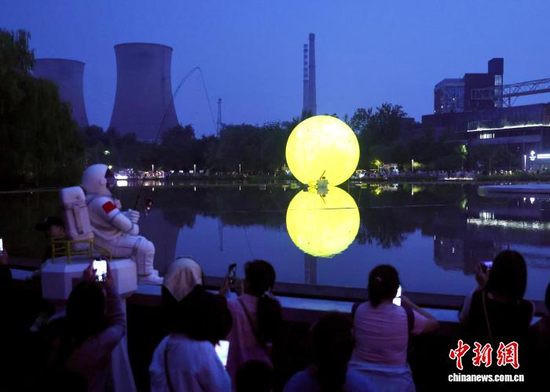 Visitors admire a moon-shaped lantern at Xiuchi Lake in Beijing’s Shougang Park on Sept. 25, 2026, the Mid-Autumn Festival. (Photo: China News Service/Yi Haifei)