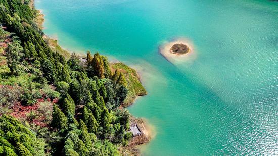 Exploring autumn beauty amid emerald-green waters in southwest China