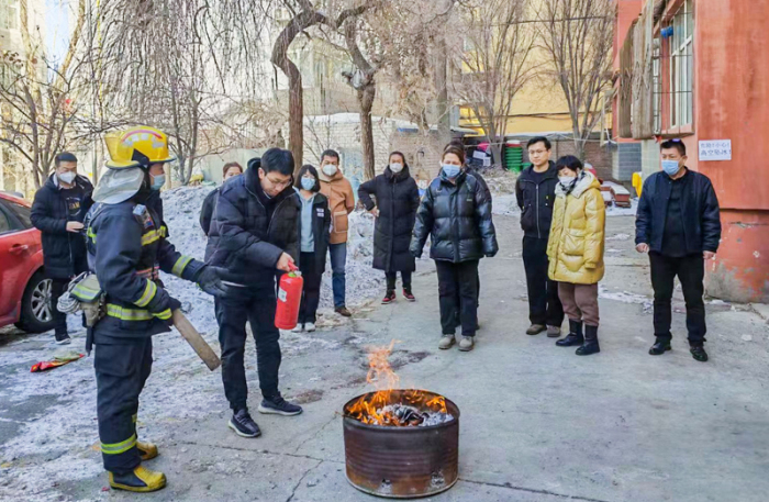 消防救援站教员给北京路口社区工作人员培训灭火器使用知识。