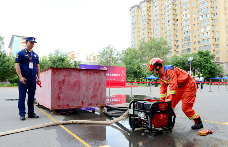 图为手抬机动泵维护及应用比拼。洪文乐 摄