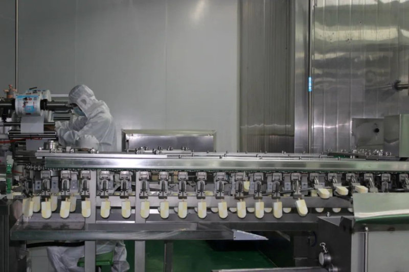 在企业生产车间，工人正在操作机器设备。