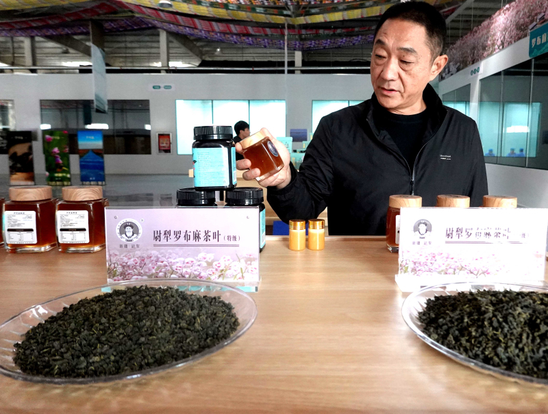 11月2日，尉犁县罗布麻茶蜜有限公司成品展示厅里，负责生产的厂长闫东向来参观的客户介绍该厂生产的罗布麻茶、罗布麻蜜。邹焰忠 摄