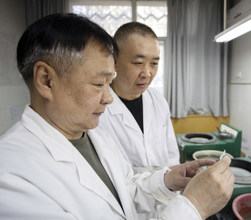 3月5日，李裕杰（左）和同事在交流石片制作经验。
