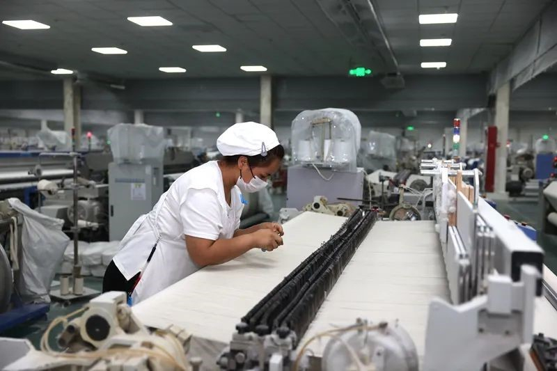 6月17日,喀什经济开发区某织布企业织造车间工人操作机器。喀什地区融媒体中心 记者陈文军 摄 6月17日,喀什经济开发区某织布企业织造车间工人操作机器。喀什地区融媒体中心 记者陈文军 摄