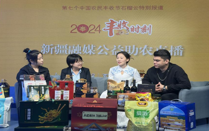 在第七个中国农民丰收节活动现场,正开展公益助农直播,四人围坐介绍阿拉山口特色产品。文亚辉 摄 在第七个中国农民丰收节活动现场,正开展公益助农直播,四人围坐介绍阿拉山口特色产品。文亚辉 摄