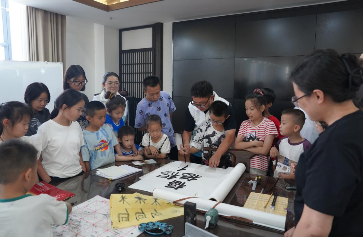 实践团成员与孩子们一起写书法。