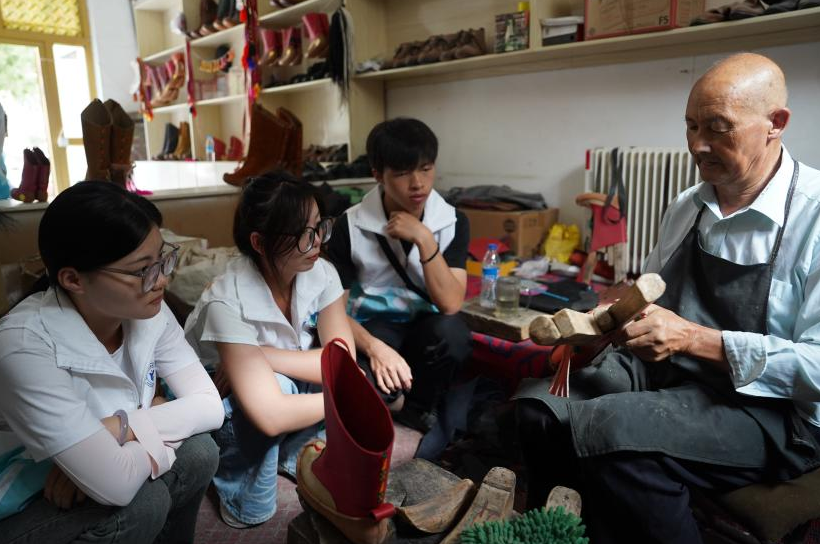 实践团观摩阿木丁·阿布都热合曼制作乔鲁克靴。