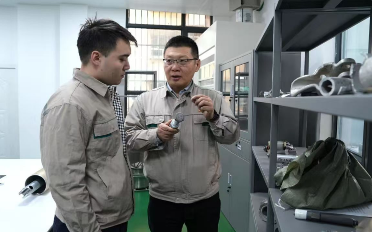 何成在给徒弟阿布莱·阿达克讲解典型失效部件情况。