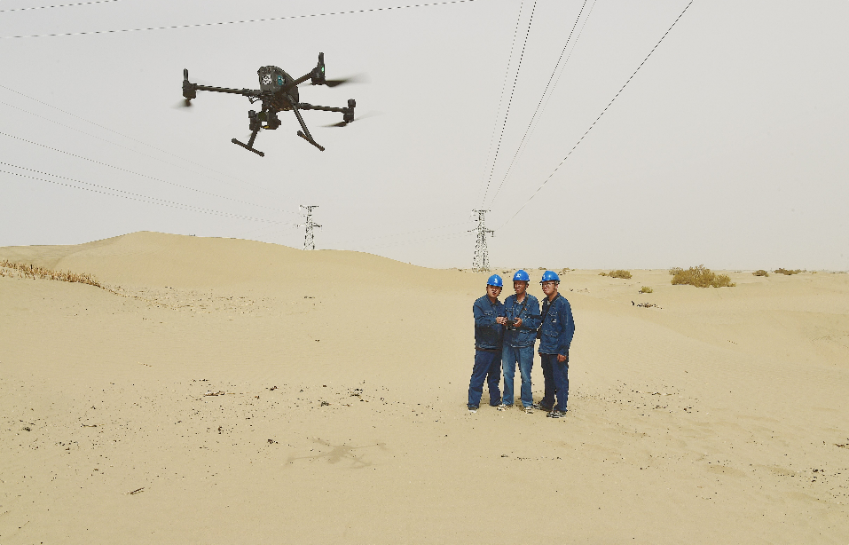 2024年5月,国网巴州供电公司员工艾合买提·托乎提和同事操控无人机对220千伏轮南塔一线路进行巡检。王骞 摄 2024年5月,国网巴州供电公司员工艾合买提·托乎提和同事操控无人机对220千伏轮南塔一线路进行巡检。王骞 摄