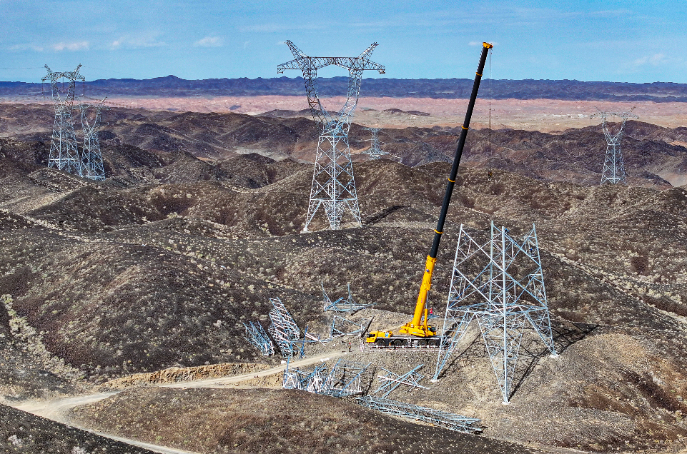 8月23日,新疆送变电公司员工正在进行塔城—乌苏π入克拉玛依750千伏线路工程立塔吊装作业。张灵军 摄 8月23日,新疆送变电公司员工正在进行塔城—乌苏π入克拉玛依750千伏线路工程立塔吊装作业。张灵军 摄