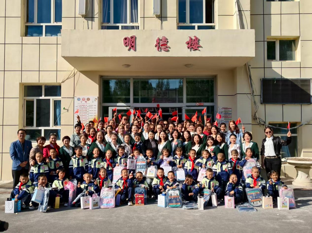 9月5日，在乌鲁木齐县小渠子中学“美疆班”开班仪式后，受助学生、家长、学校老师与新疆女企业家协会的爱心企业家们合影留念。 陈慧 摄