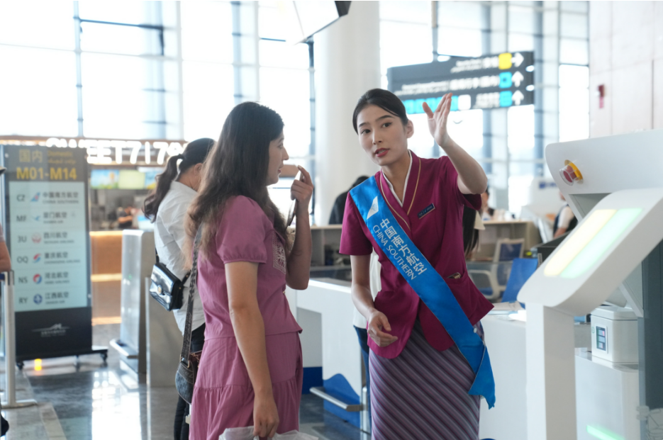 南航工作人员为旅客指引方向。骆俊峰 摄