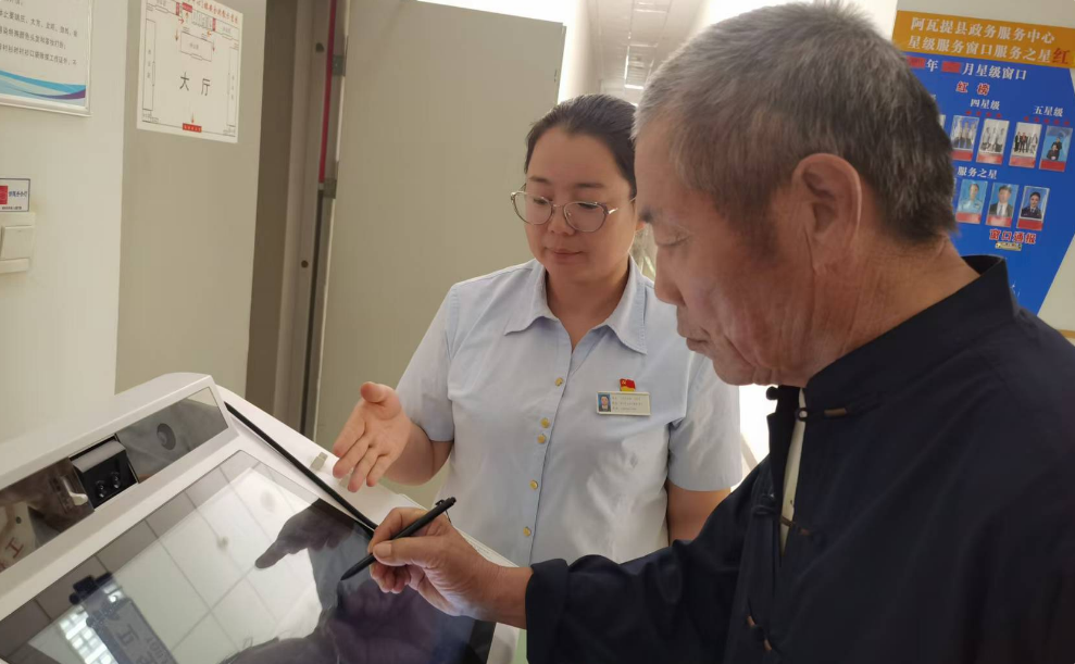图为阿克苏塔里木农商银行工作人员协助老年客户在智慧柜员机上办理补卡业务。
