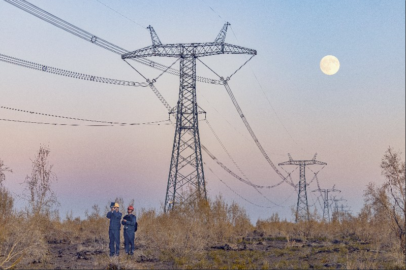 10月6日,新疆送变电公司员工在吉木萨尔县五彩湾镇附近巡视±1100千伏昌吉—古泉特高压直流输电线路。张灵军 摄 10月6日,新疆送变电公司员工在吉木萨尔县五彩湾镇附近巡视±1100千伏昌吉—古泉特高压直流输电线路。张灵军 摄