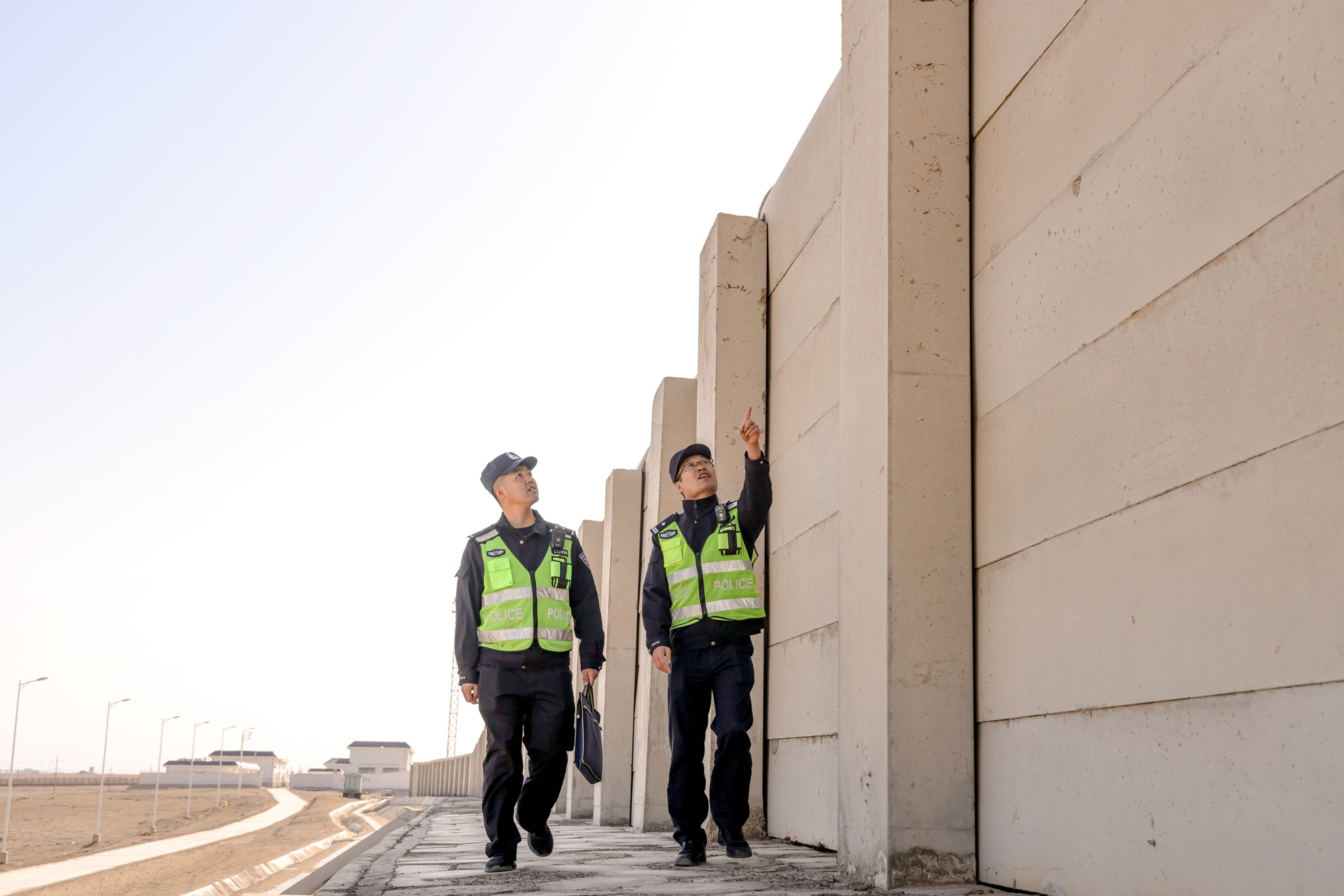民警对兰新客专线防风墙进行隐患排查。