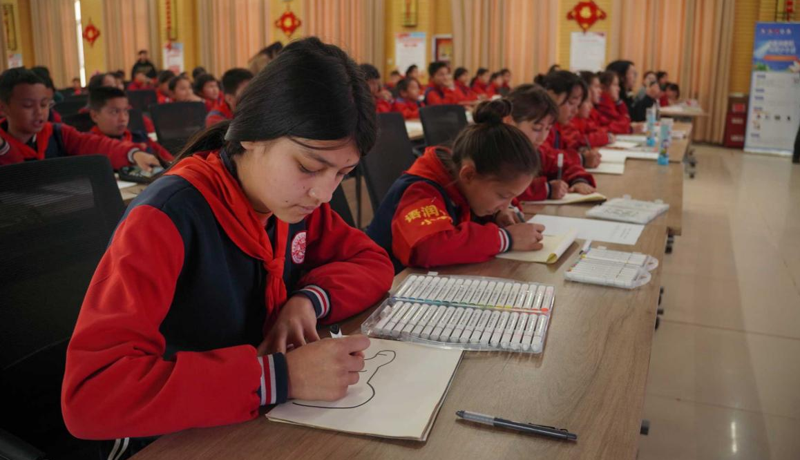 10月28日，“红领巾爱阅读——石榴籽一家亲，手拉手共成长”新疆数字农家书屋喀什地区活动中，喀什地区疏附县托克扎克镇中心小学的少先队员们与中少总社“阅读+”全国名师、著名书画家仇立权现场互动，学习画马。高溢蔓 摄