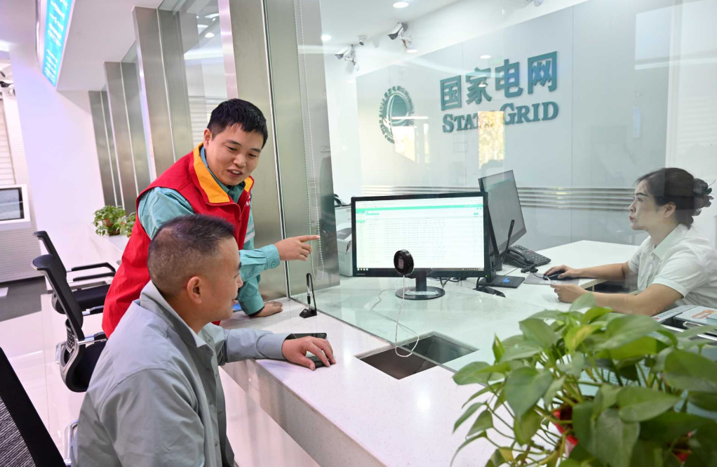 在阿克苏市晶水路营业厅,供电员工正在向办理业务的用户进行介绍水电气暖联合报装服务。马海骄 摄 在阿克苏市晶水路营业厅,供电员工正在向办理业务的用户进行介绍水电气暖联合报装服务。马海骄 摄