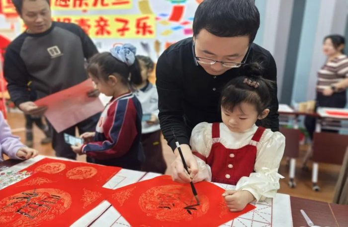 孩子与家长一起写福字。