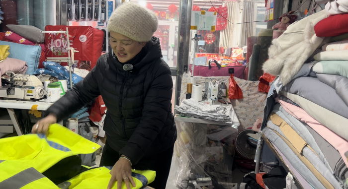 裁缝店老板为吾斯曼江的“战损版”大衣安装拉链。