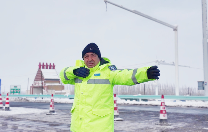 吾斯曼江·吾曼尔正在工作岗位上指挥交通。