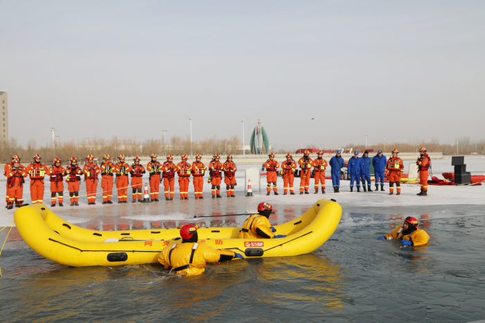 图为演练现场，消防救援人员利用无动力充气艇救援技术应急落水群众。