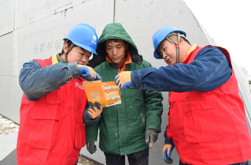 国网奎屯供电公司工作人员向种植户宣传安全用电知识。