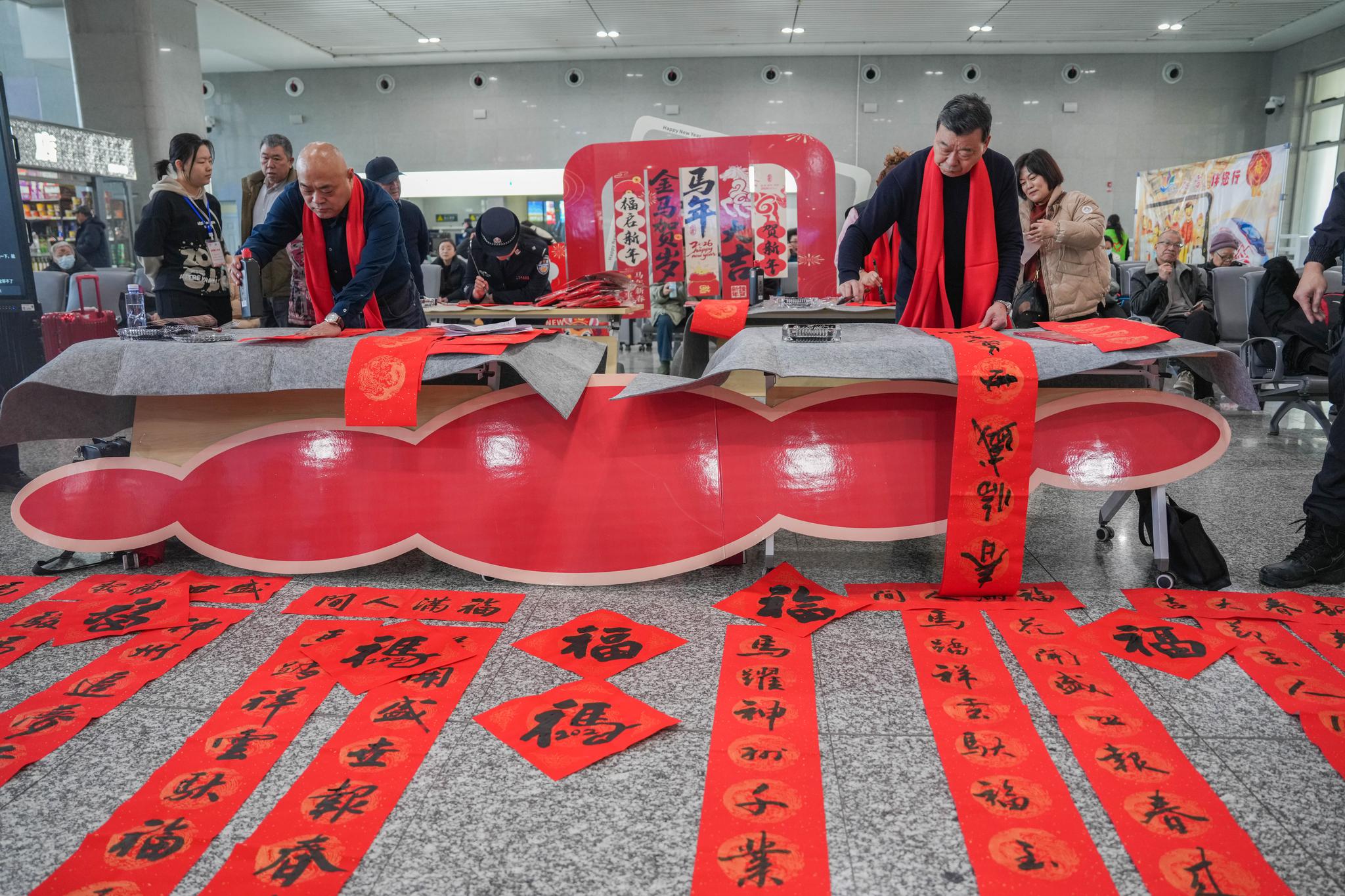 2月10日,哈密公安处民警联合哈密市书法家协会成员在哈密火车站候车室书写祝福春联。 2月10日,哈密公安处民警联合哈密市书法家协会成员在哈密火车站候车室书写祝福春联。