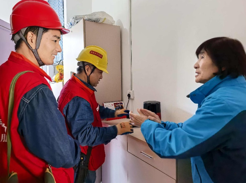 供电员工对天山花园小区居民用电设施进行节前检查。臧春雪 摄