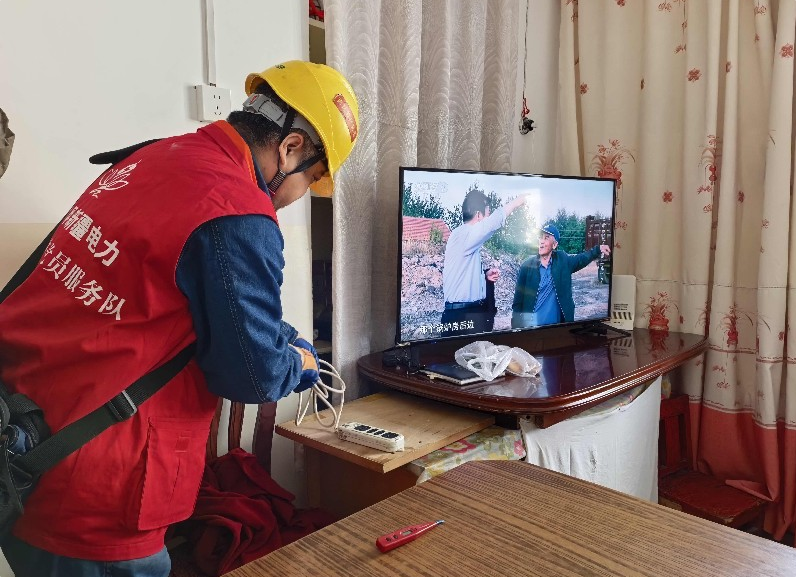 供电员工免费更换居民家中的老旧插线板外壳。臧春雪 摄