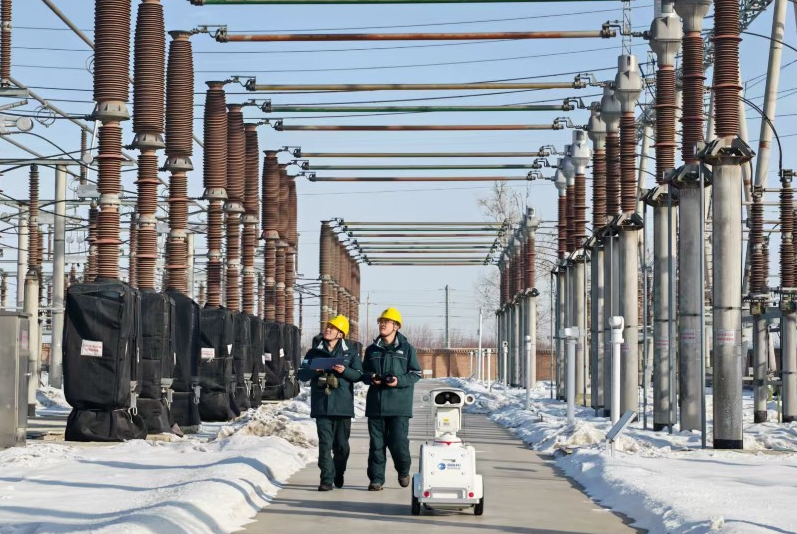 2月19日，国网昌吉供电公司工作人员在昌吉市220千伏长宁变电站通过“人工+机器人”方式巡检变电站设备。蒋淮丞 摄