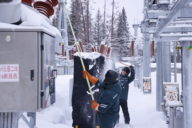 3月11日，新疆阿勒泰地区喀纳斯景区遭遇寒潮侵袭，气温骤降至零下22摄氏度，景区内积雪厚度达50厘米，同时伴随风吹雪天气。为全力守护景区供电生命线，国网阿勒泰供电公司运维人员对变电站站内道路、设备区开展清雪作业。努尔别克·努尔曼 摄
