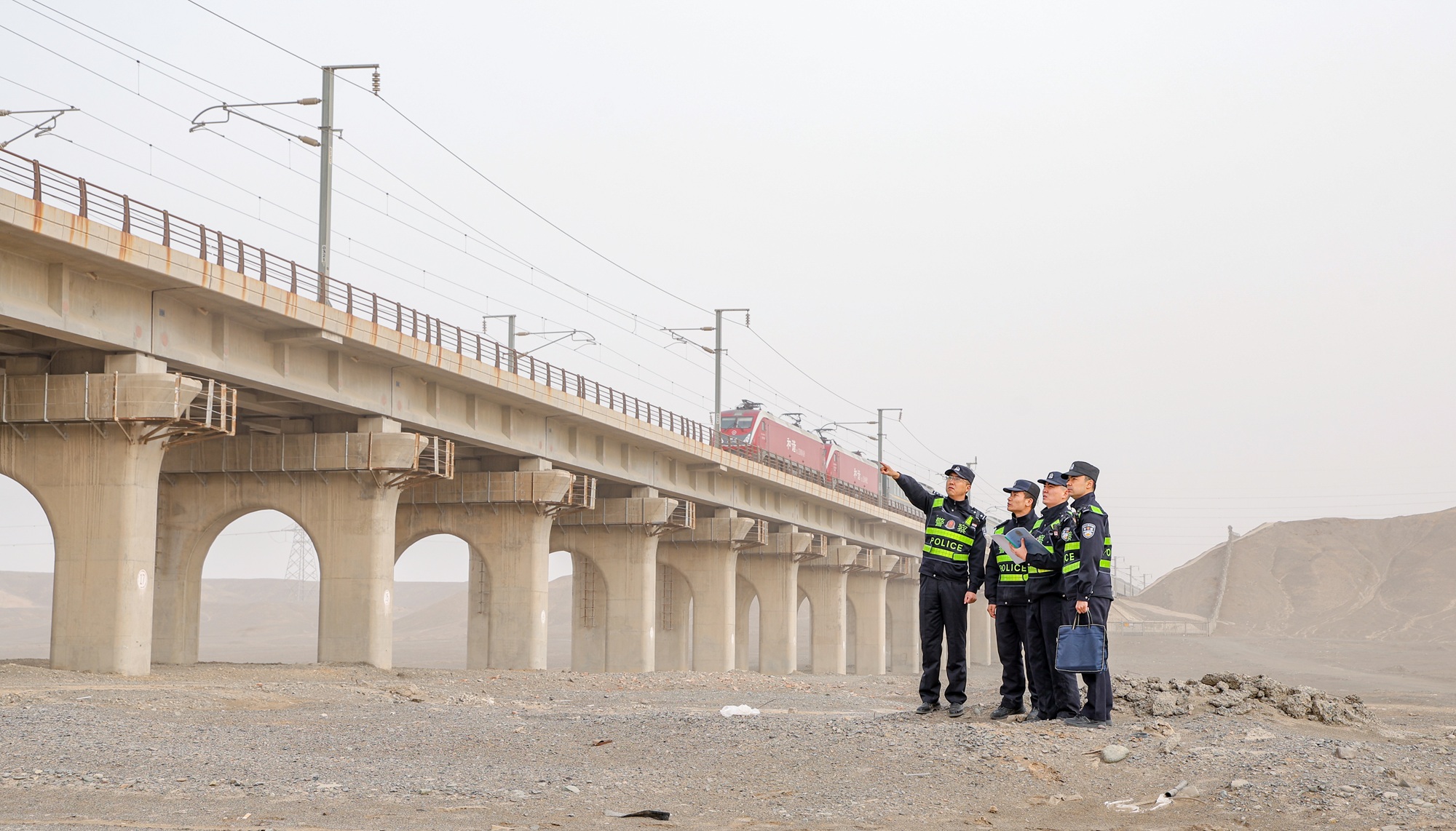 民警在沙尘天气下对兰新客专线物防设施开展安全巡查。