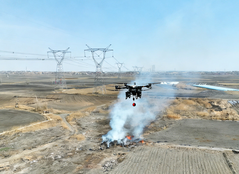 4月7日，新疆送變電公司員工在750千伏烏格一線應(yīng)用大載重?zé)o人機(jī)進(jìn)行滅火作業(yè)。彭森 攝