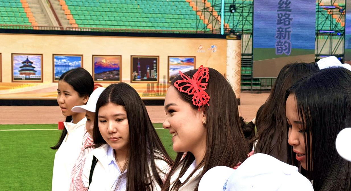 哈薩克斯坦青年現(xiàn)場(chǎng)制作并佩戴中國(guó)剪紙頭花。高楠 攝