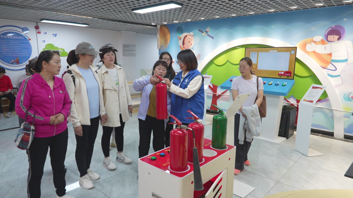 图为社区组织居民开展灭火器实操培训。