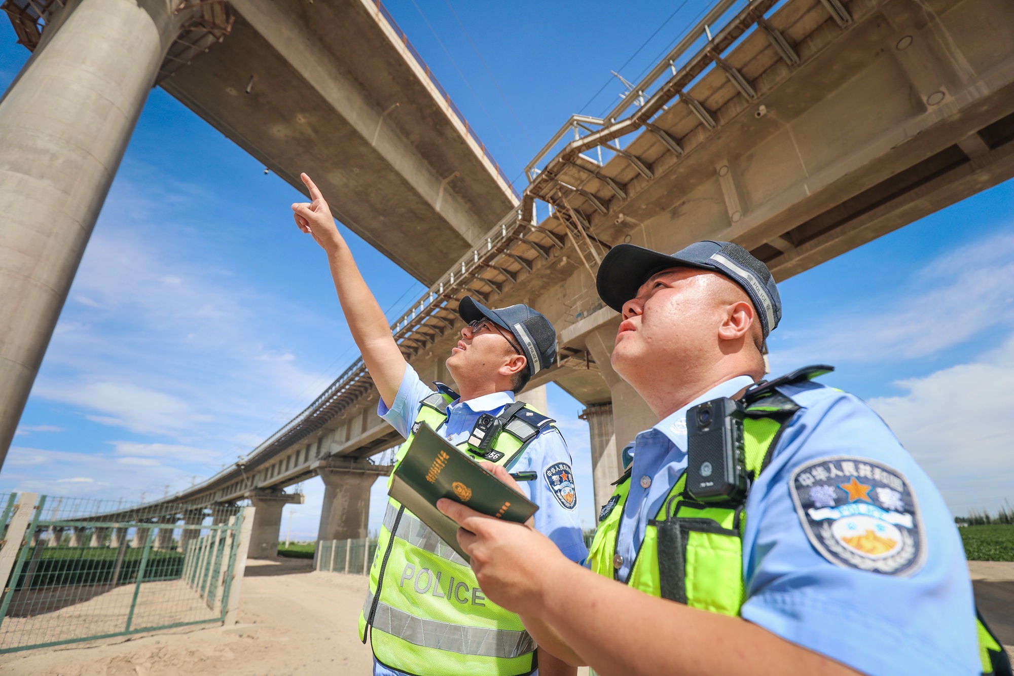 民警顶烈日对铁路线路重点区段进行检查登记。