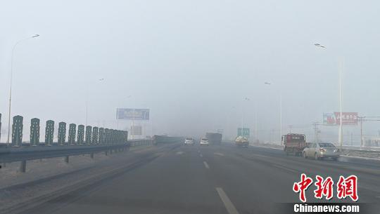乌鲁木齐至昌吉快速路两旁楼宇“消失”在雾气中。 王小军 摄 乌鲁木齐至昌吉快速路两旁楼宇“消失”在雾气中。 王小军 摄