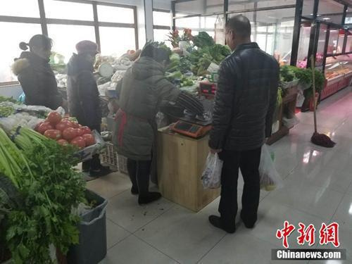 西城区某菜市场内,一名市民使用免费塑料袋买菜。 冷昊阳 摄 点击进入下一页
