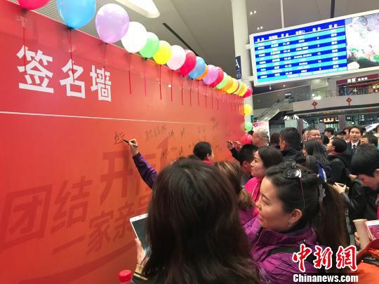 准备乘坐“民族团结一家亲号”特快旅客列车前往和田探亲的人员在签名墙留下最真挚的祝福。 迪娜 摄 c