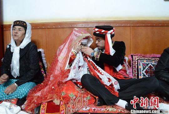 新郎卡比力正在喂自己的新娘子祖木莱提喝茶,婚礼仪式结束后,这对新人将启程前往男方家。 勉征 摄 新郎卡比力正在喂自己的新娘子祖木莱提喝茶,婚礼仪式结束后,这对新人将启程前往男方家。 勉征 摄