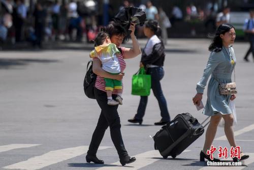 5月15日,湖南長沙持續高溫,市民頭頂烈日出行。 <a target='_blank' href='http://www.chinanews.com/'>中新社</a>記者 楊華峰 攝 5月15日,湖南長沙持續高溫,市民頭頂烈日出行。 中新社記者 楊華峰 攝