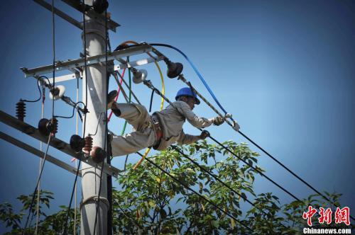資料圖:福州一電力作業人員冒37度高溫爬上電桿作業,確保民眾在最短時間內恢復供電。王東明 攝 資料圖:福州一電力作業人員冒高溫爬上電桿作業。王東明 攝