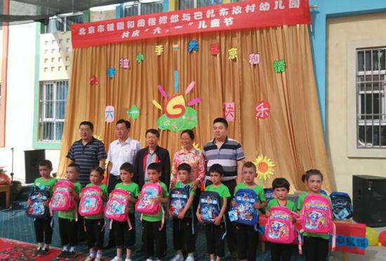图为北京援疆干部在墨玉县托胡拉乡阿亚克古热村幼儿园与维吾尔族小朋友合影。 图为北京援疆干部在墨玉县托胡拉乡阿亚克古热村幼儿园与维吾尔族小朋友合影。