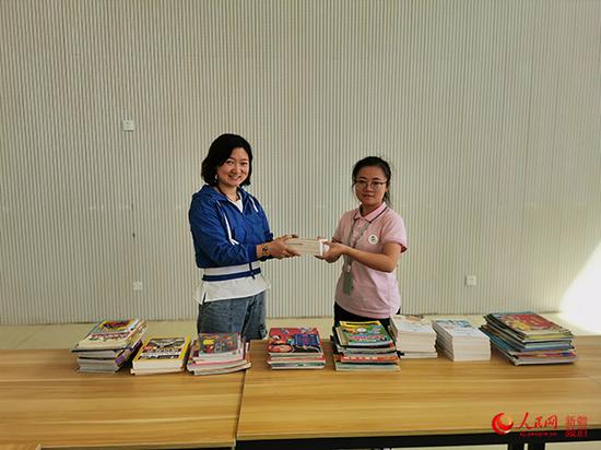 圖為北京援疆老師劉愛華(左)為幼兒園捐書。